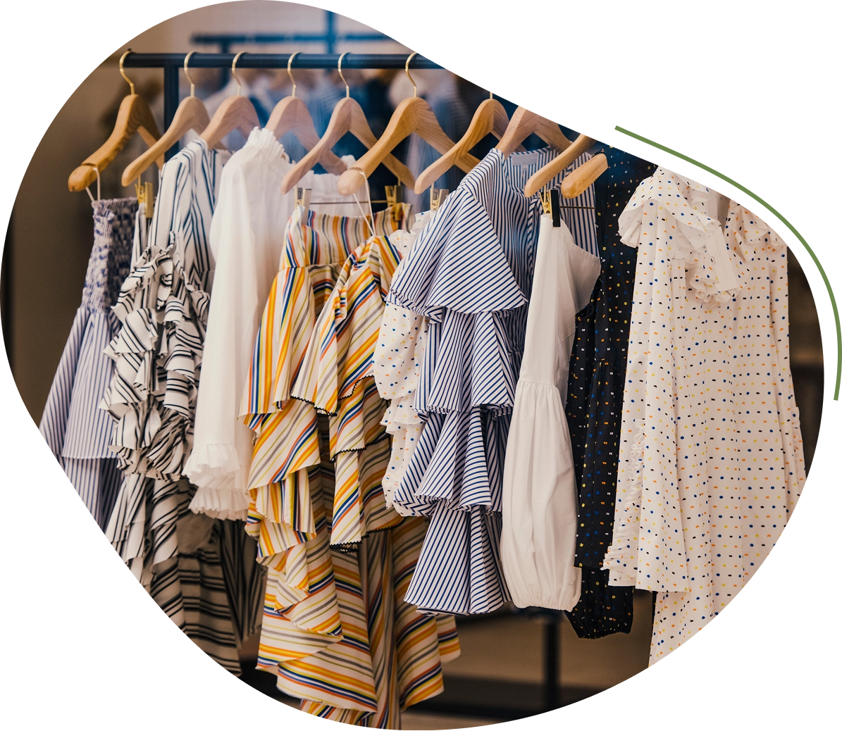 Colorful dresses hanging on wooden hangers.